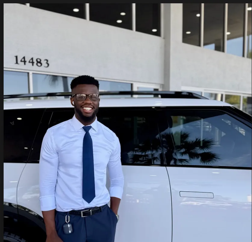 Ricky Providence standing beside a white vehicle
